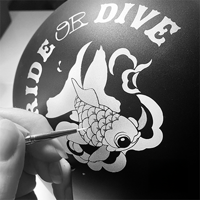 photo en noir et blanc d'un poisson peint sur un casque de moto personnalisé par l'artiste